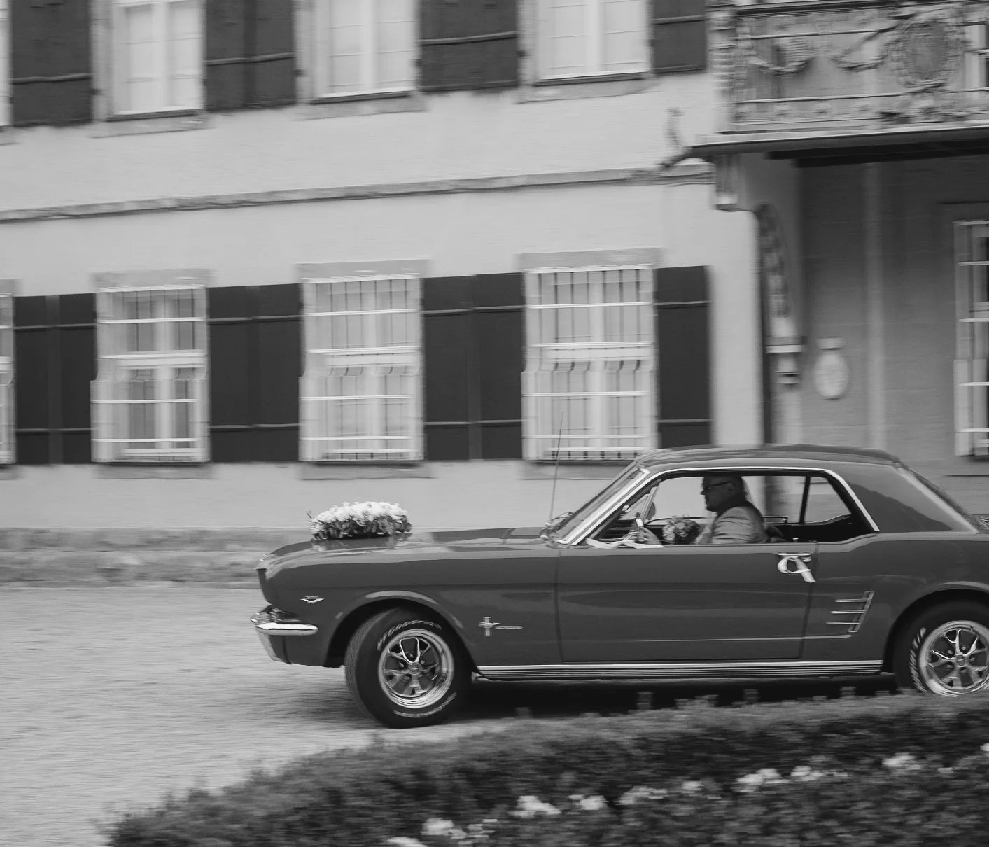Hochzeitspaar im Ford Mustang vor dem Schloss Ammerdingen