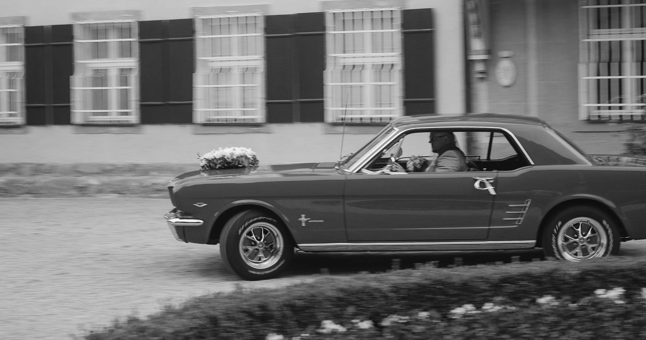 Hochzeitspaar im Ford Mustang vor dem Schloss Ammerdingen